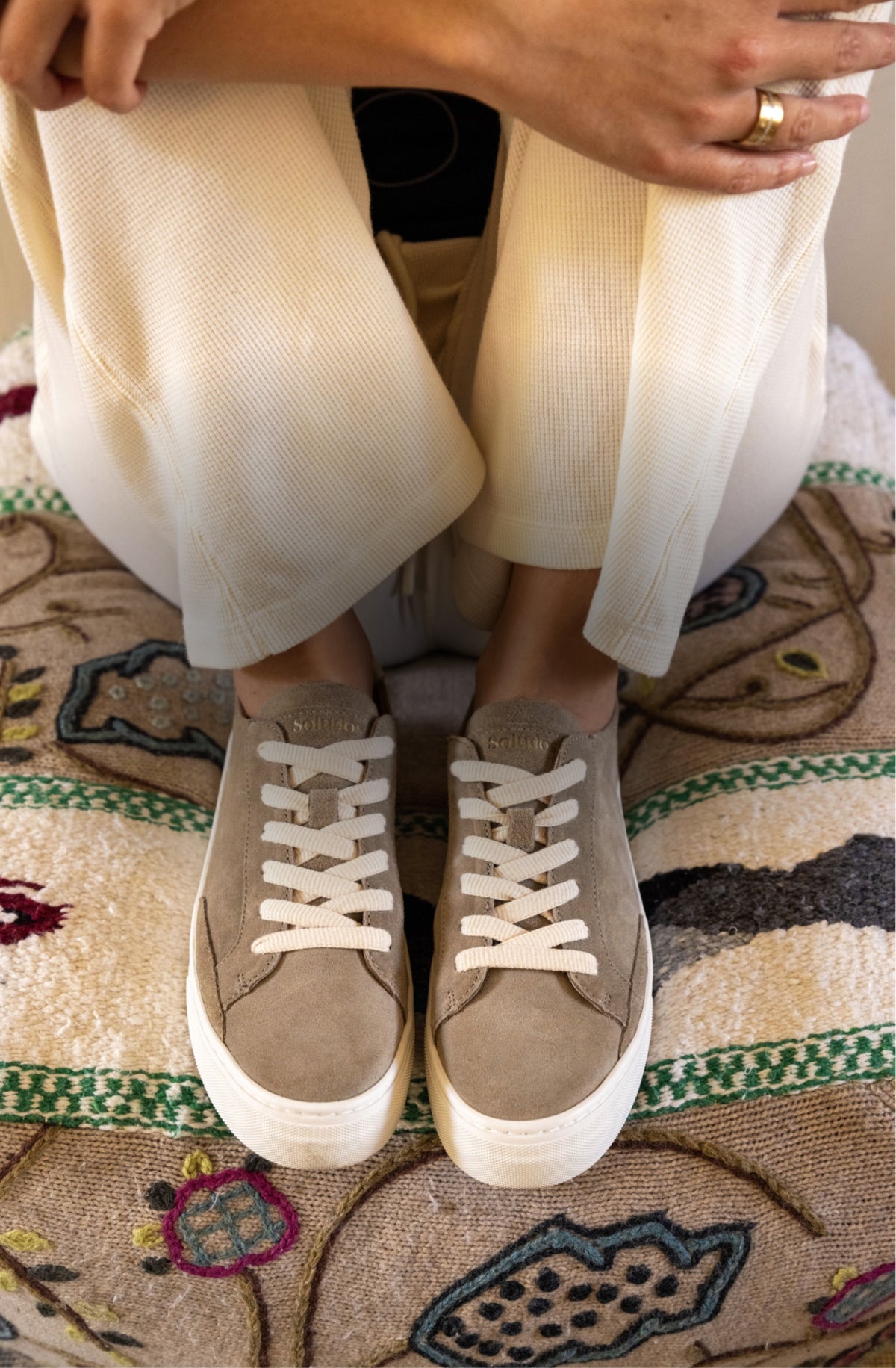 Soludos taupe suede sneakers with white laces and rubber soles.
