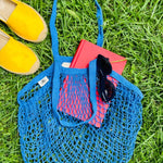 Blue bag laying on grass outside